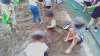 砂の布団を友達につくってもらう児童